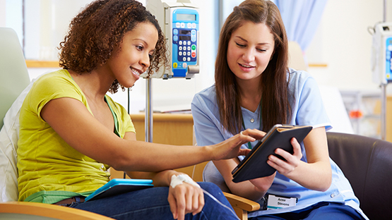 A woman using an interpretation device communicating with a health care worker