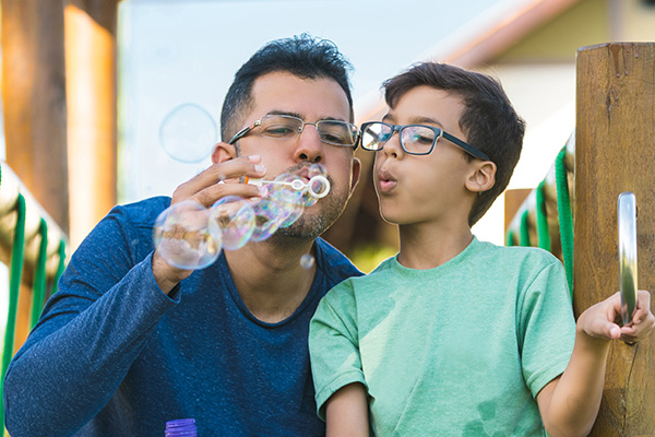 A man and his child blowing bubbles